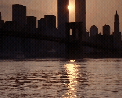 A Bridge Over A Body Of Water With The Sun Shining On It GIF