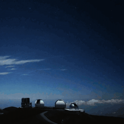 A Bright Light Shines Brightly In The Night Sky Above A Building GIF