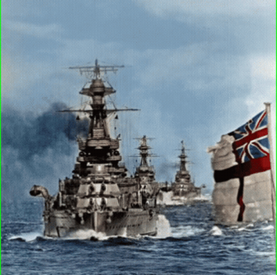 A British Flag Flies In Front Of A Row Of Ships GIF