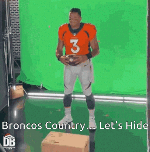A Broncos Football Player Is Standing In Front Of A Green Screen And Holding A Football . GIF