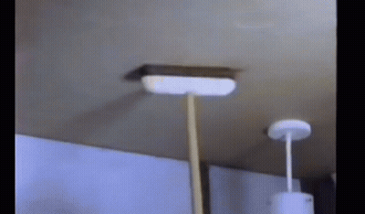 A Broom Is Hanging From A Ceiling In A Room . GIF