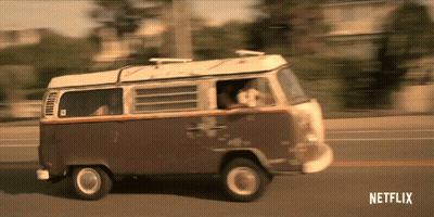 A Brown And White Van Is Driving Down A Street With Netflix Written On The Bottom Of The Screen GIF