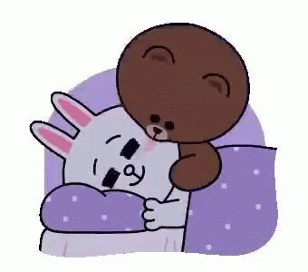 A Brown Bear And A White Rabbit Are Sleeping In A Bed . GIF