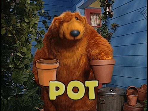 A Brown Bear Is Holding Two Pots In Front Of A House GIF
