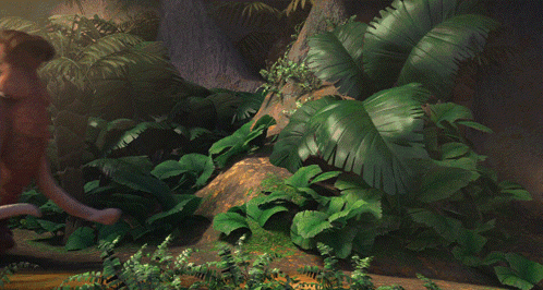 A Brown Elephant With A Large Tusks Is Standing In A Jungle GIF