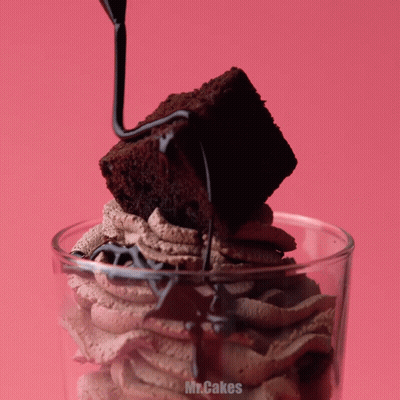 A Brownie Is Being Poured Into A Glass With The Words Mr.cakes Written On The Bottom GIF
