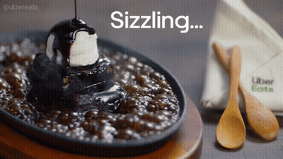 A Brownie With A Scoop Of Ice Cream On Top And The Words Sizzling Written Above It GIF