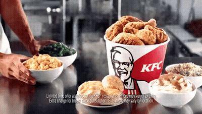 A Bucket Of Fried Chicken Sits On A Counter Next To Bowls Of Macaroni And Cheese And Mashed Potatoes GIF