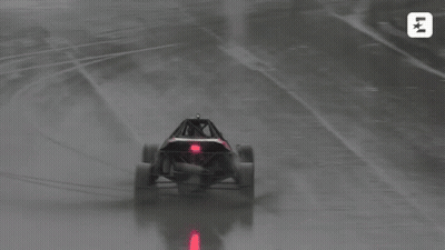 A Buggy Is Driving On A Wet Track With The Letters Lk On The Bottom Left GIF