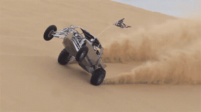 A Buggy Is Going Down A Sand Dune With A Flag On Top GIF