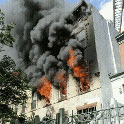 A Building That Is On Fire With Smoke Coming Out Of It GIF