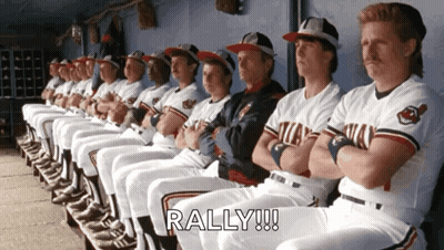 A Bunch Of Baseball Players Are Sitting In A Dugout And The Word Rally Is On The Bottom Right GIF