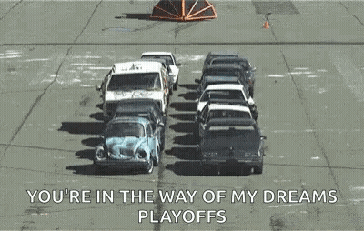 A Bunch Of Cars Are Sitting On Top Of Each Other In A Parking Lot And A Truck Is Carrying Them . GIF