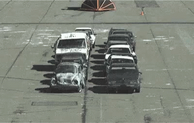A Bunch Of Cars Are Stacked On Top Of Each Other In A Parking Lot And One Of The Cars Has The Word Police On It GIF
