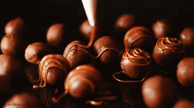 A Bunch Of Chocolate Balls Are Sitting On A Table With Graydriver Written On The Bottom GIF
