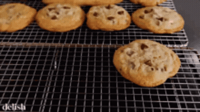 A Bunch Of Chocolate Chip Cookies On A Wire Rack GIF