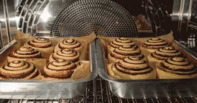 A Bunch Of Cinnamon Rolls Are In A Pan In An Oven GIF