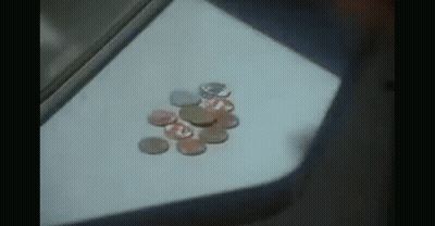 A Bunch Of Coins On A Table With One That Says ' A ' On It GIF