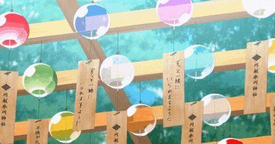 A Bunch Of Colorful Balls Hanging From A Wooden Beam With Chinese Writing On Them GIF