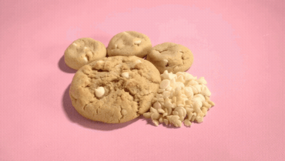 A Bunch Of Cookies On A Pink Surface GIF