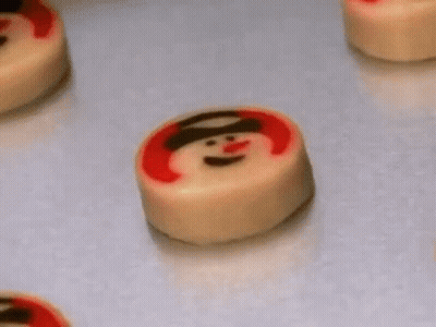 A Bunch Of Cookies With Snowmen On Them On A Table . GIF