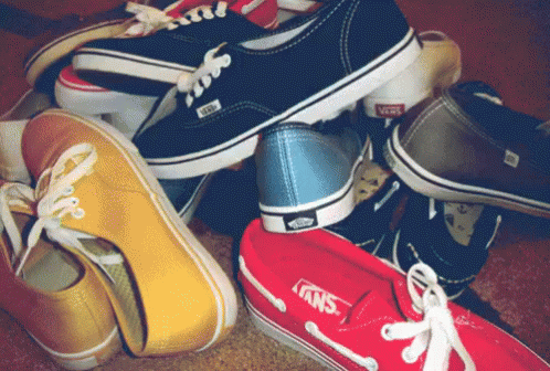 A Bunch Of Different Colored Vans Shoes Stacked On Top Of Each Other GIF