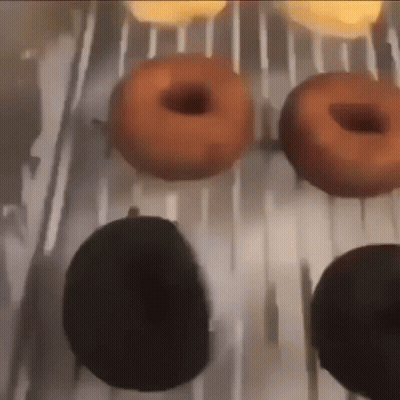 A Bunch Of Donuts Are Sitting On A Tray GIF