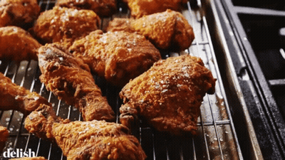 A Bunch Of Fried Chicken On A Rack With The Word Delish On The Bottom Right GIF