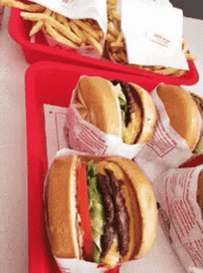 A Bunch Of Hamburgers Are On A Red Tray With French Fries GIF