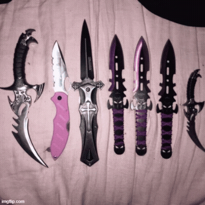 A Bunch Of Knives Are Lined Up On A Pink Cloth Including A Pink Knife With A Cross On It GIF