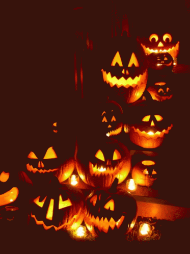 A Bunch Of Pumpkins With Faces Carved In Them GIF