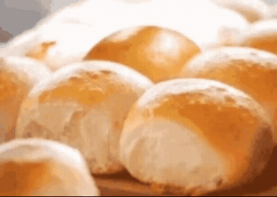 A Bunch Of Rolls Are Sitting On A Table . GIF