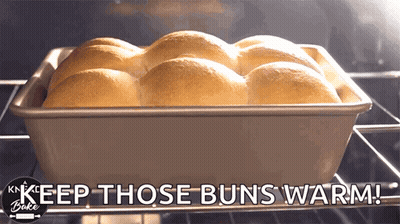 A Bunch Of Rolls In A Pan With The Words Keep Those Buns Warm Below Them GIF