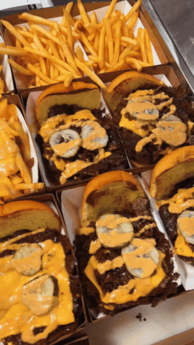A Bunch Of Sandwiches And French Fries In A Box GIF