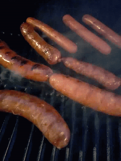 A Bunch Of Sausages Cooking On A Grill With Smoke Coming Out Of Them GIF