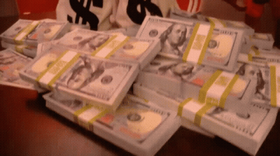 A Bunch Of Stacks Of Money On A Table GIF