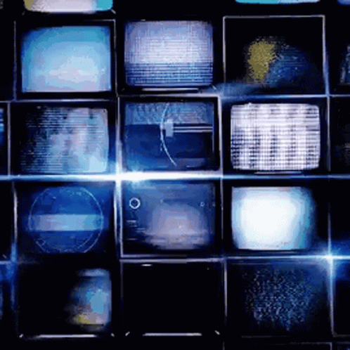 A Bunch Of Televisions Are Stacked On Top Of Each Other On A Wall GIF