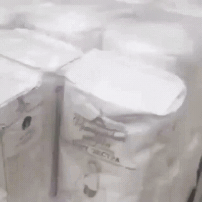 A Bunch Of White Boxes Are Sitting On A Table . GIF
