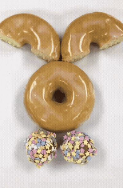 A Bunny Face Made Out Of Donuts And Sprinkles On A White Surface GIF