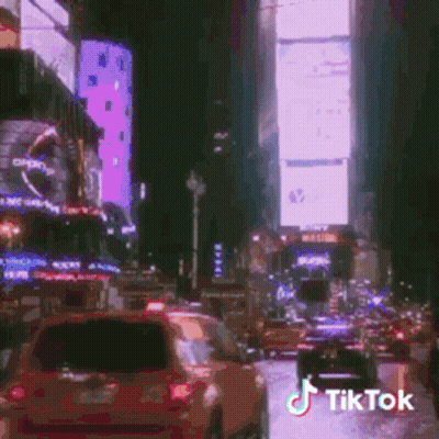 A Busy City Street At Night With A Tik Tok Watermark GIF