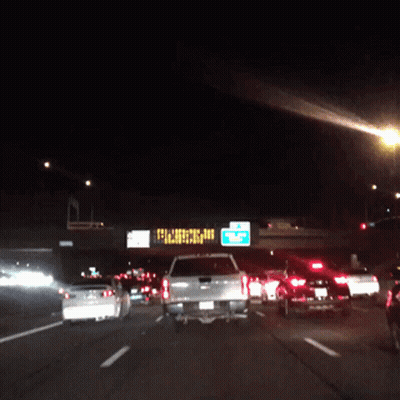 A Busy Highway At Night With A Sign That Says ' Closed ' On It GIF