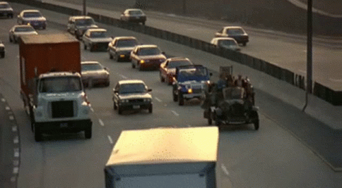 A Busy Highway With Cars And Trucks Going Down It GIF