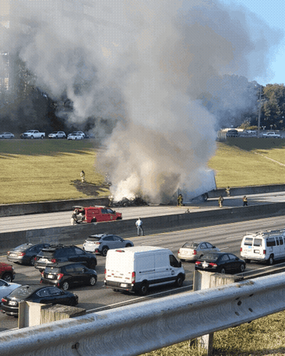 A Busy Highway With Smoke Coming Out Of A Truck That Is On Fire GIF