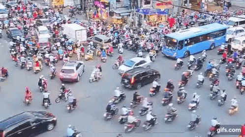 A Busy Intersection With A Lot Of Motorcycles And Cars . GIF