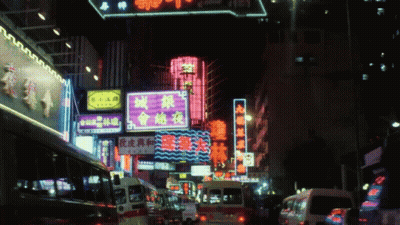 A Busy Street At Night With A Neon Sign That Says ' A ' On It GIF