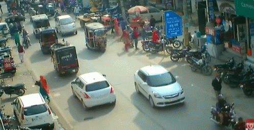A Busy Street With A Blue Sign That Says ' Toyota ' On It GIF