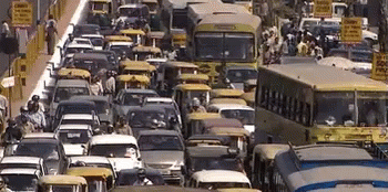 A Busy Street With A Lot Of Cars And Buses And A Sign That Says ' No Parking ' On It GIF