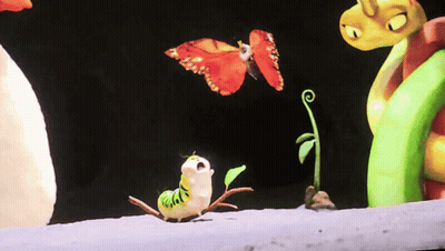 A Butterfly Is Flying Over A Caterpillar With A Green Plant In The Background GIF