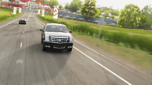 A Cadillac Is Driving Down A Road With A Sign That Says ' A ' On It GIF