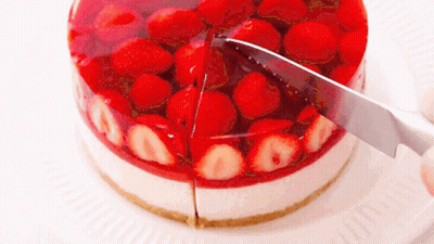 A Cake With Strawberries And Jelly Is Being Sliced By A Knife GIF